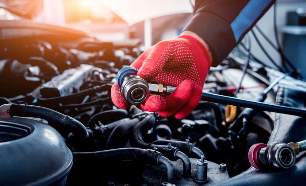 Person's Gloved Hands Maintaining a Car's Air Conditioning