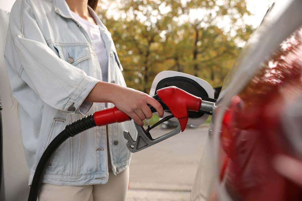 Woman pumping gas into her car