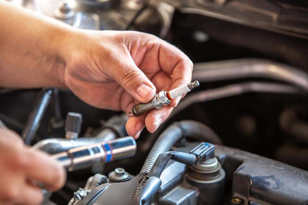 Person Changing a Sparkplug in a Car Engine