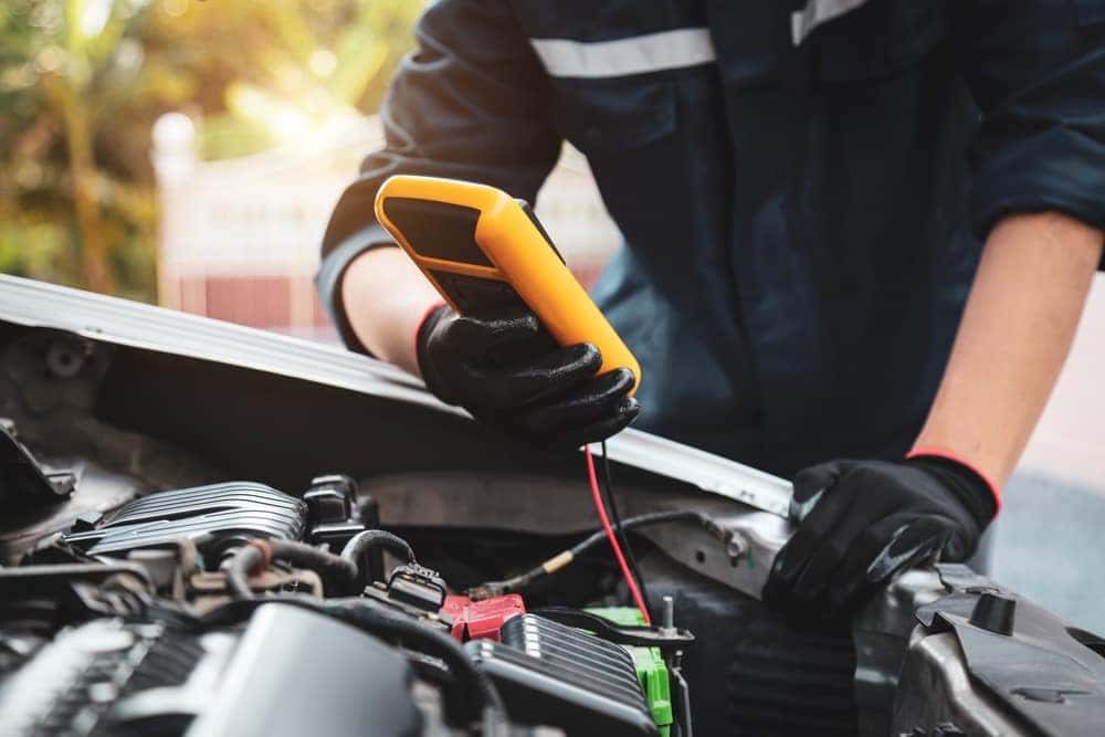 Mechanic testing a battery during car maintenance