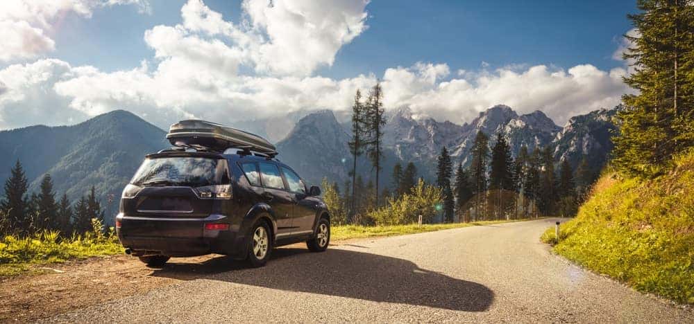 SUV on the road with mountains in the background