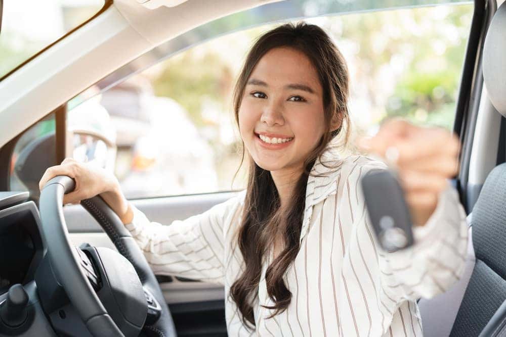 Woman smiling after purchasing a used GMC or Buick