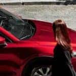 Red 2019 Mazda CX-5 Grand Touring Reserve side profile from above on street with woman walking to passenger door