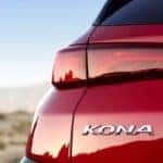 Closeup of rear left side of red 2019 Hyundai Kona in desert