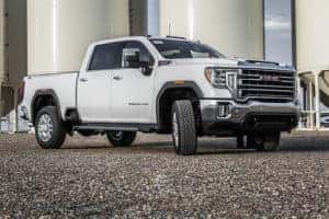 White 2020 GMC Sierra Truck in Front of Grain Silos